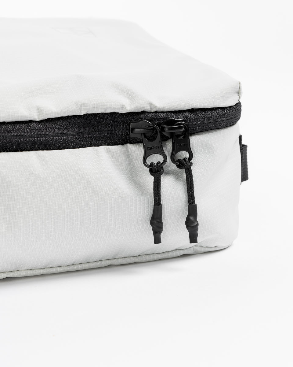 a studio shot the dual-zips on a white packing cube 11l