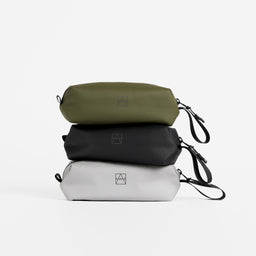 A studio shot of the pencil cases in all 3 colours stacked on top of each other including All Black