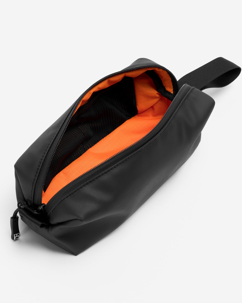 a studio shot of the interior and orange lining in a black pencil case