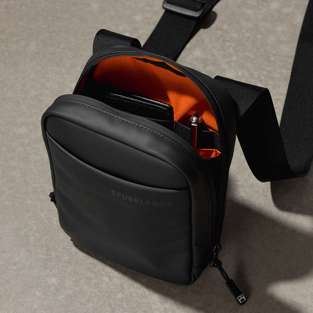 a close up of an All Black shoulder bag showing the interior pockets